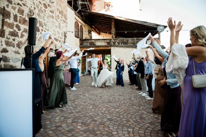 Einzug des Brautpaars in den Innenhof von Schloss Payersberg, die Gäste winken mit Servietten